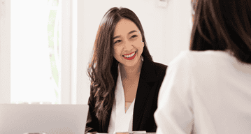 A woman consulting a client after graduating from a business administration & management course at WOU.